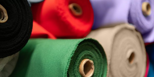 Collection of fashionable fabrics. Samples of different natural fabrics for sewing a fashion collection of clothes. Large selection of fabrics in the store or tailor warehouse.